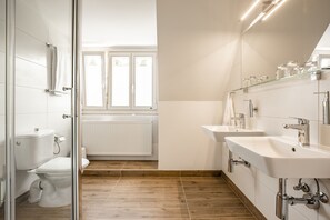 Habitación cuádruple familiar | Baño | Ducha, artículos de higiene personal gratuitos y secador de pelo