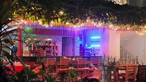 An outdoor bar area with seating and a staircase. - Apartelle de Francesca (Puerto Galera)