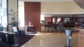 Hotellin aula, jossa on vastaanottotiski, baarialue ja oleskelutila.