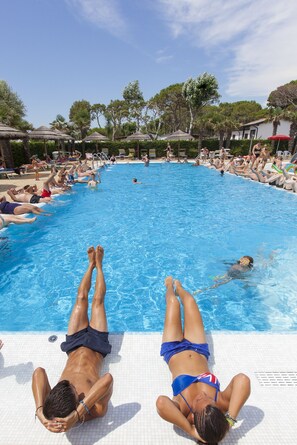A swimming pool with people sunbathing and swimming. - Vela Blu Camping Village (Cavallino-Treporti)