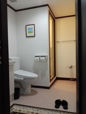 Une petite salle de bain avec des toilettes, un tableau encadré au mur et un porte-serviettes.