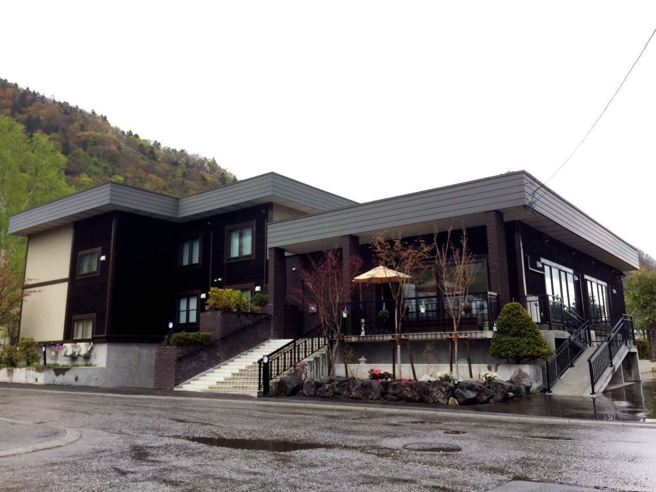 A modern two-story building with a flat roof, a covered entrance area, and a staircase leading to the upper floor. - Hotel Kinwaso (Sapporo)
