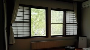 A room with tatami flooring, a low table, and a radiator. - Hotel Kinwaso (Sapporo)