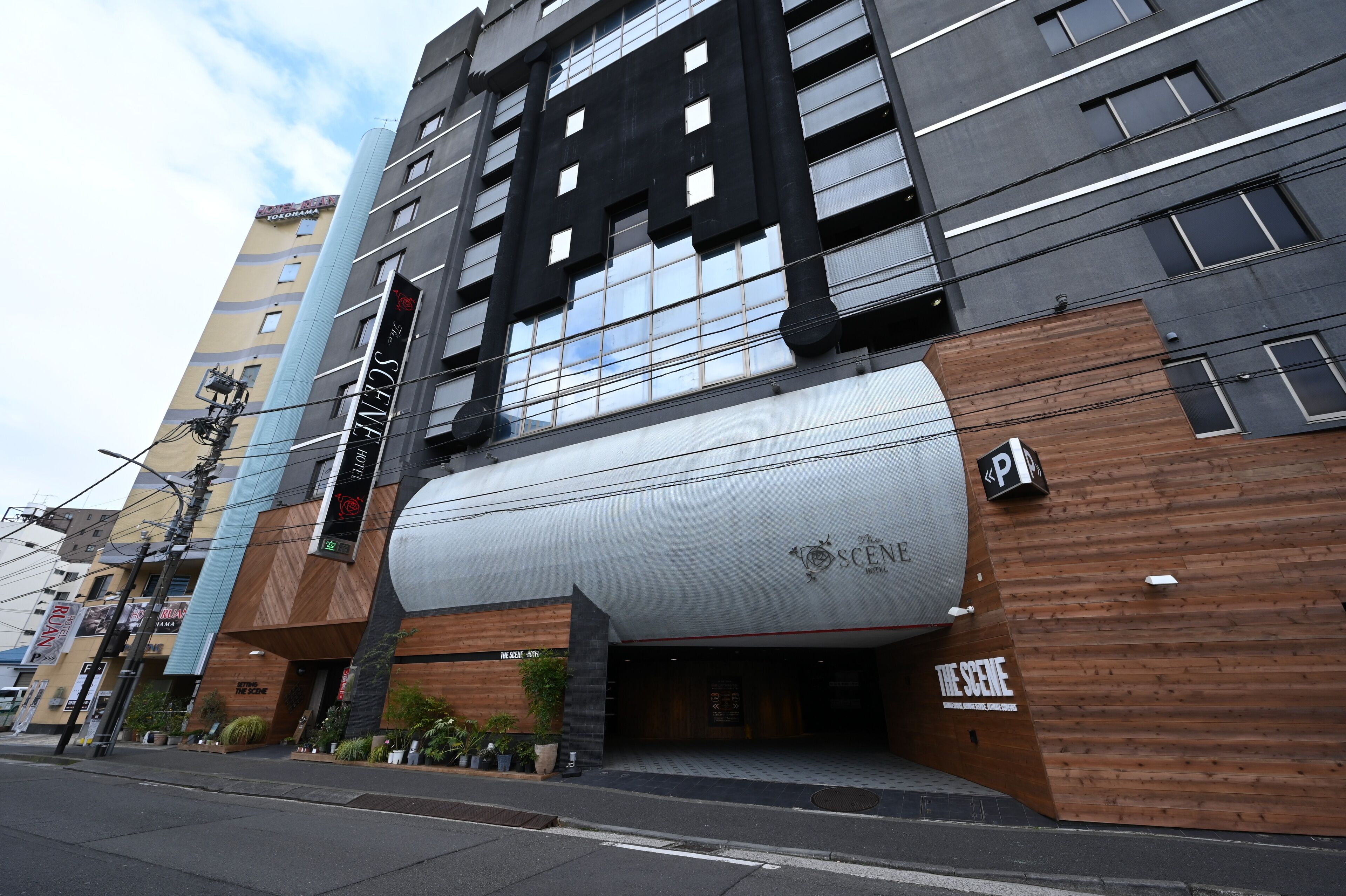 A modern hotel with a prominent sign reading "The Scene Hotel."