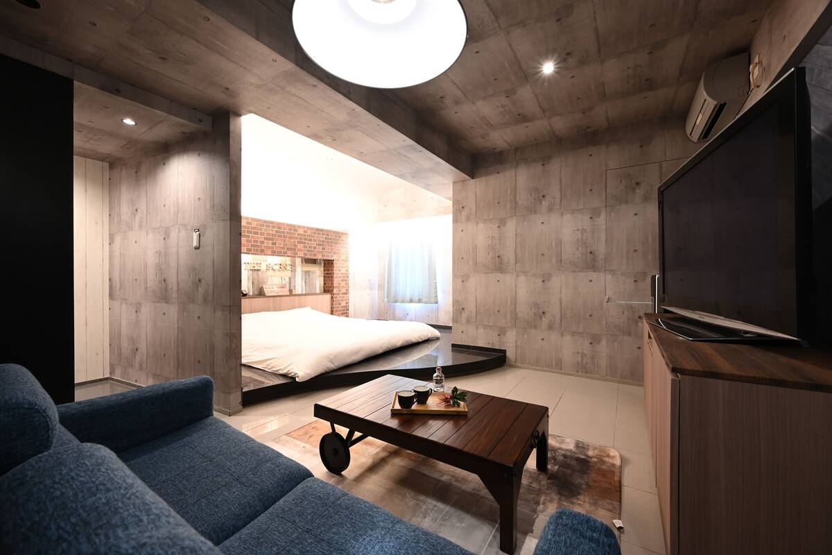 A modern living room with a sofa, a coffee table, and a TV.