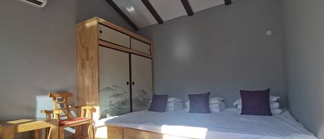 A bedroom with a large bed, wooden furniture, and a ceiling fan.