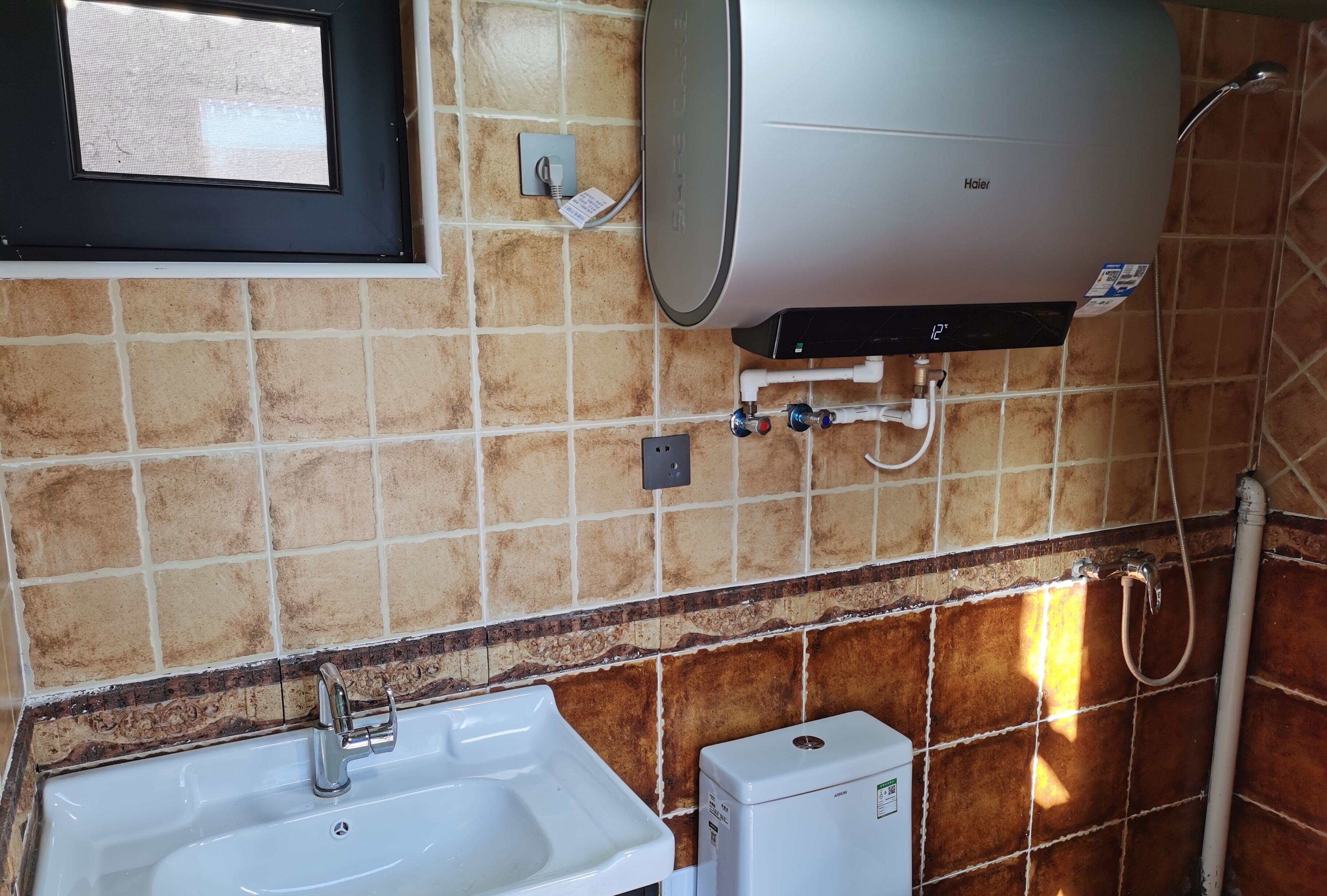 Un baño con lavamanos blanco, calefactor y ducha.