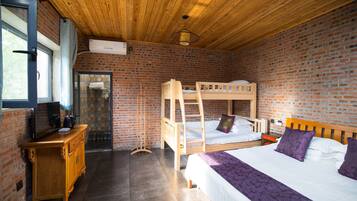 Una habitación con una litera, un aparador de madera, una ventana y una pared de ladrillo.