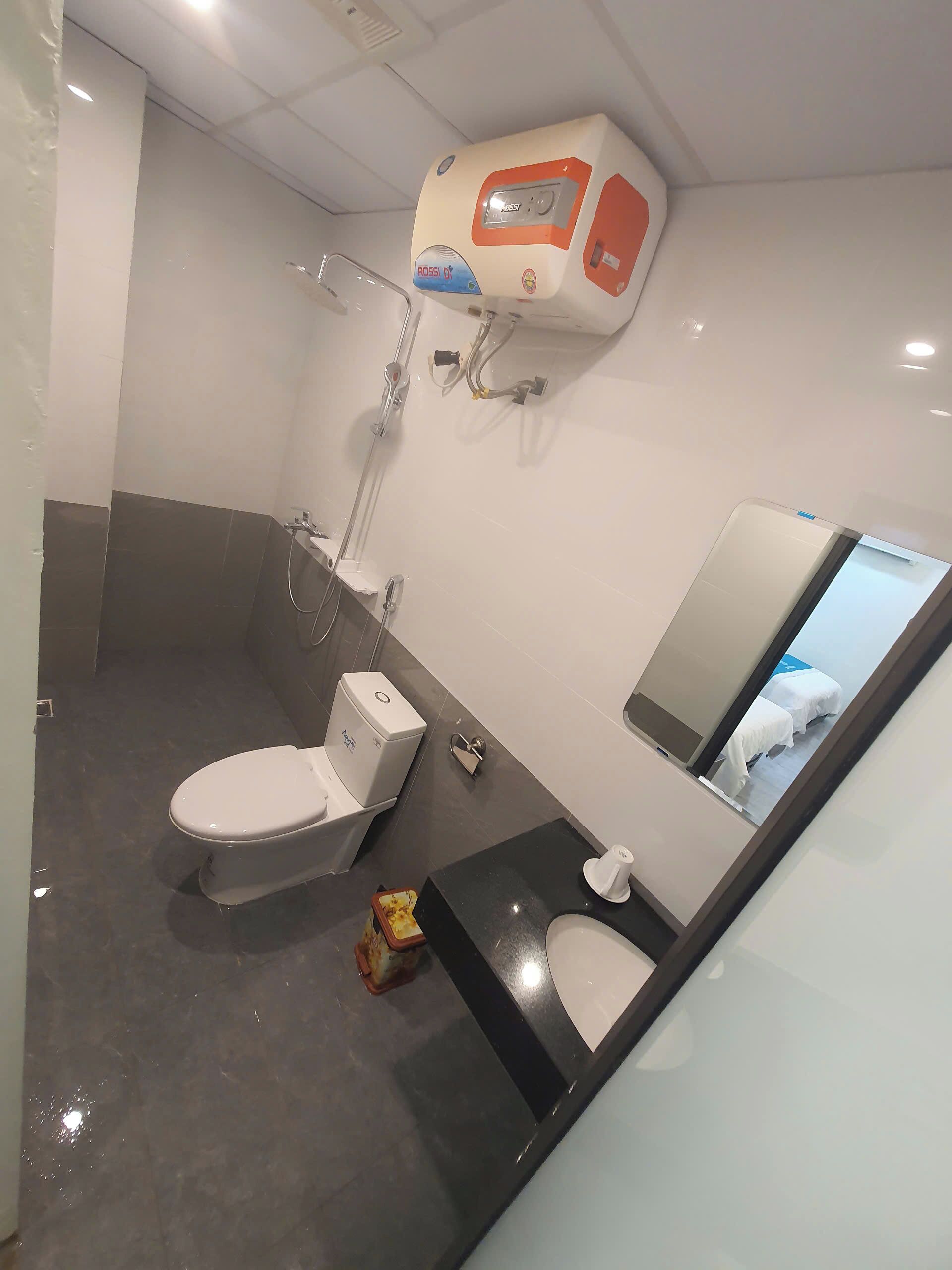 Un baño con inodoro, bidé y espejo.