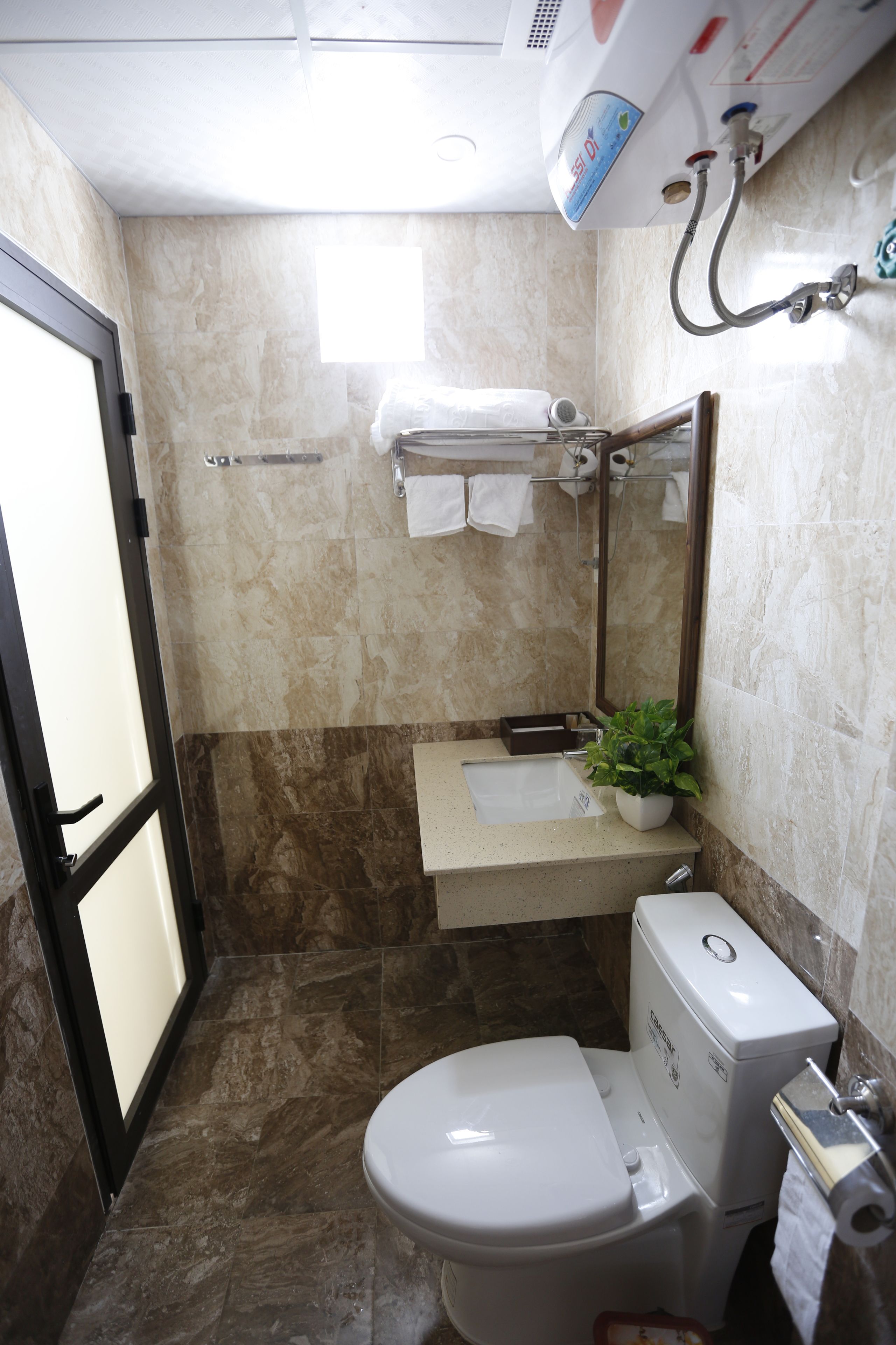 Ein kleines Badezimmer mit Toilette, Waschbecken und Spiegel.