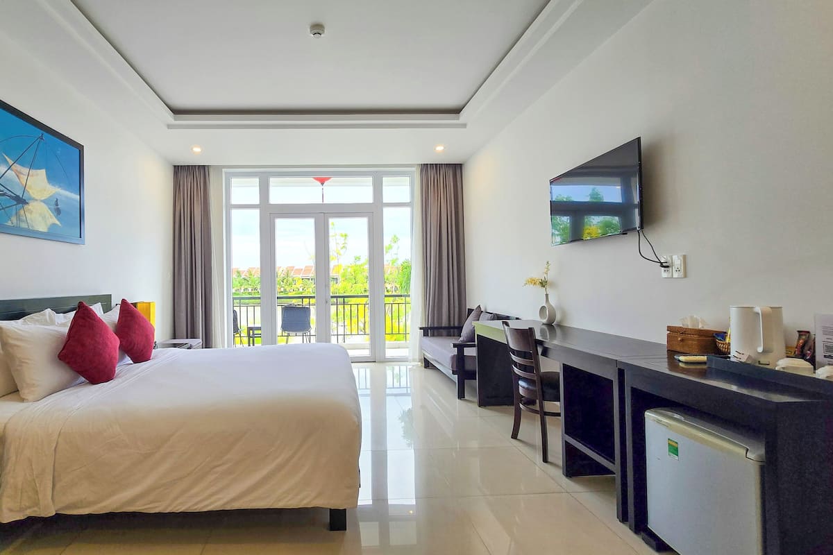A hotel room with a bed, desk, and TV.