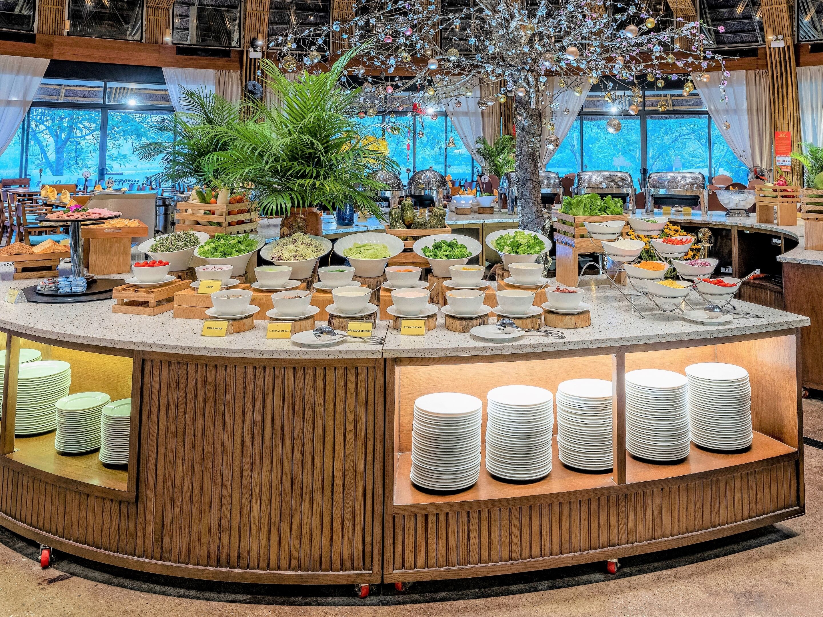 A buffet setup with various food items and a decorative tree centerpiece.