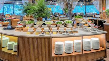 A buffet setup with various food items and a decorative tree centerpiece.