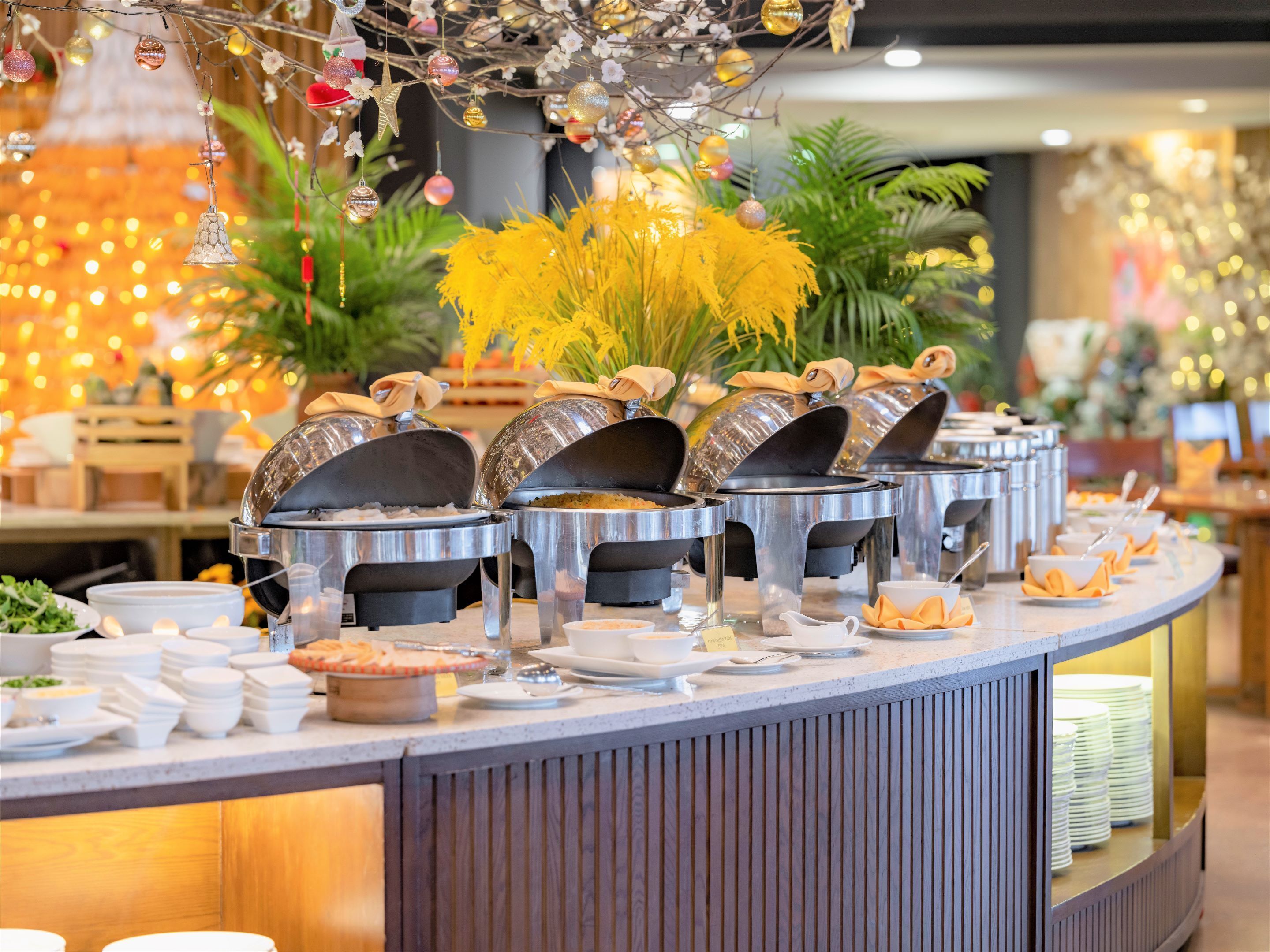 A buffet setup with multiple serving stations, covered food containers, and a variety of dishes and utensils.