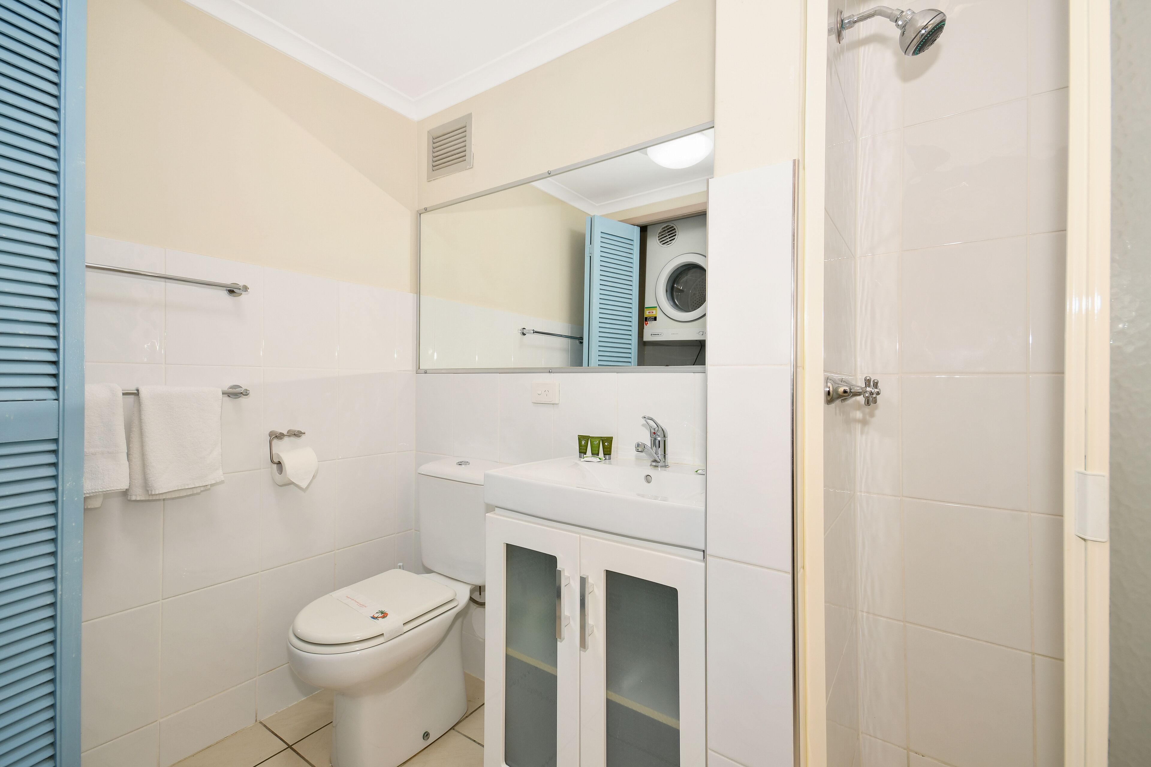 Ein Badezimmer mit Toilette, Waschbecken, Spiegel und Dusche.
