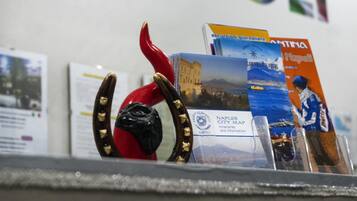 Une table présente des brochures de voyage et une sculpture représentant un piment rouge.