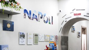 A reception area with a large 'NAPOLI' sign, informational posters, and a welcome sign. - B&B Viva Napoli (Naples)