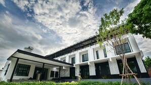A modern two-story building with a flat roof, large windows, and a covered entrance area. - BY Hotel Kanchanaburi (Kanchanaburi)