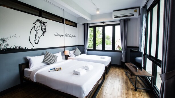 A hotel room with two beds, a desk, and a large window. - BY Hotel Kanchanaburi (Kanchanaburi)