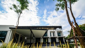 A modern two-story house with a flat roof, large windows, and a covered outdoor area. - BY Hotel Kanchanaburi (Kanchanaburi)