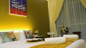 A hotel room with a bed, pillows, a nightstand, a lamp, and a window with curtains. - Hazotel Semarang (Semarang)