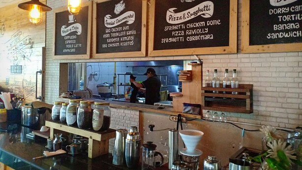 A restaurant interior with hanging signs listing menu items like pizza, spaghetti, and chicken dome. - Hazotel Semarang (Semarang)