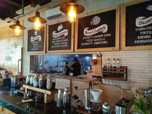 A restaurant interior with hanging signs listing menu items like pizza, spaghetti, and chicken dome. - Hazotel Semarang (Semarang)