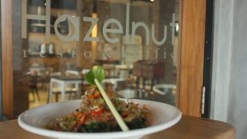 A restaurant window with a plate of food on a table.