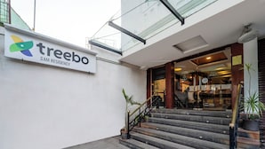 A building entrance with a staircase leading to a ground floor. A signboard with the name "treebo SAM RESIDENCY" is visible. - Treebo Sam Residency (Coimbatore)