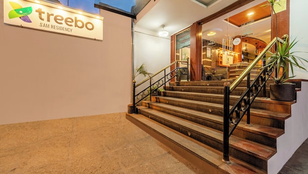 A staircase leading to a reception area with a sign for 'treebo SAM RESIDENCY'. - Treebo Sam Residency (Coimbatore)