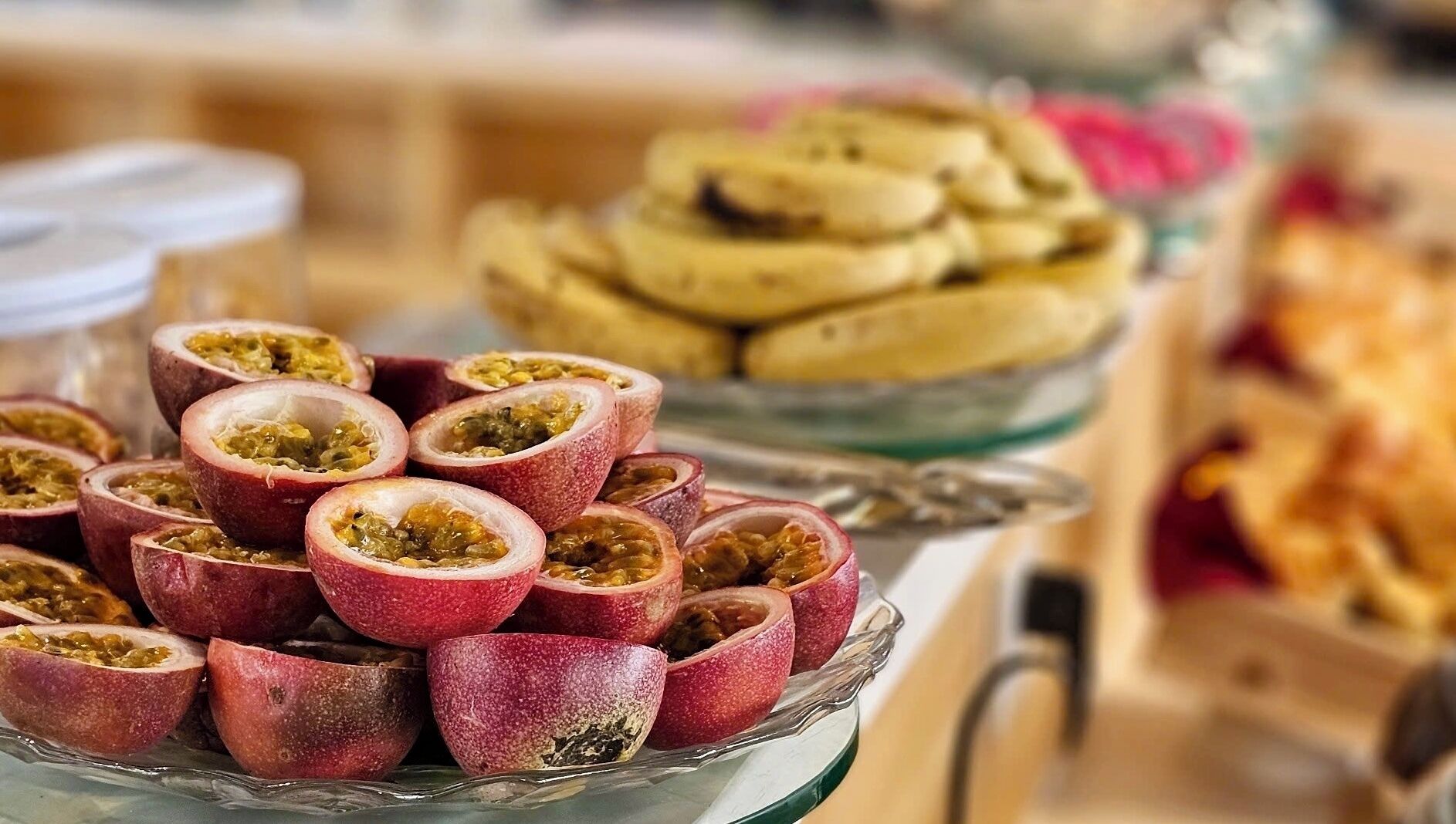 A buffet with various dishes, including a bowl of sliced passion fruit.
