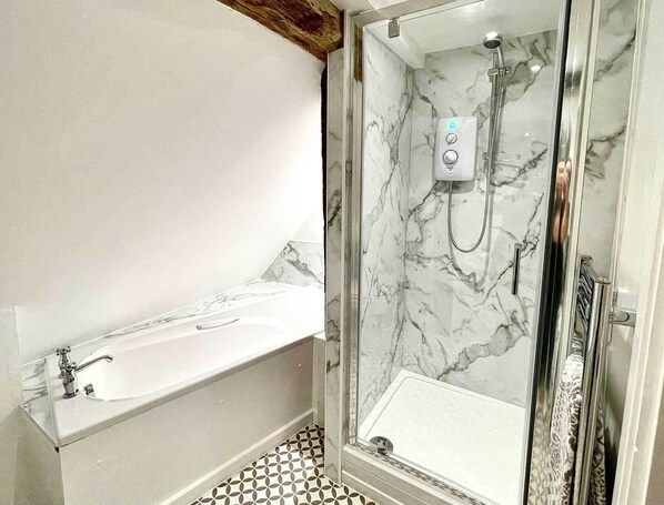 A bathroom with a marble shower, a bathtub, and a sink. - Walnut Tree House (Littlehampton)