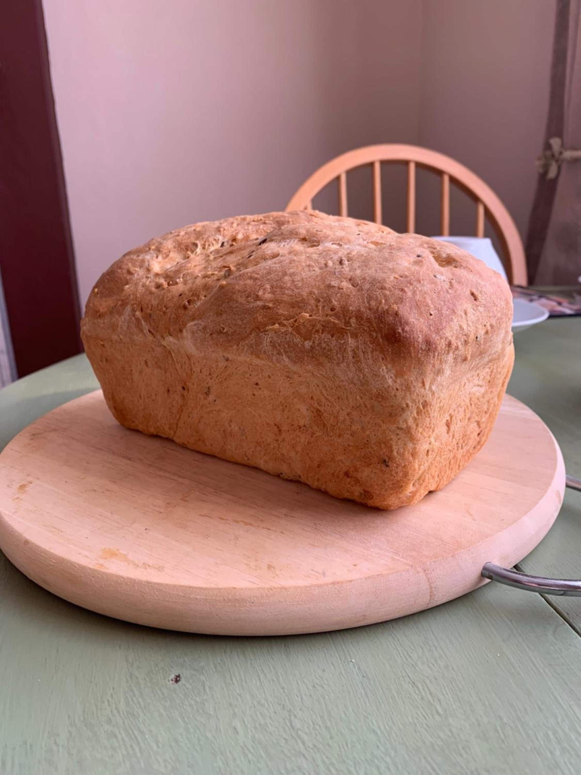 A loaf of bread on a wooden cutting board.