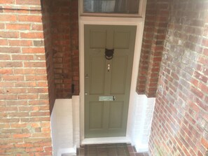 A green door with a small window above it, a mail slot, and a doorbell. - Number29 (Shanklin)