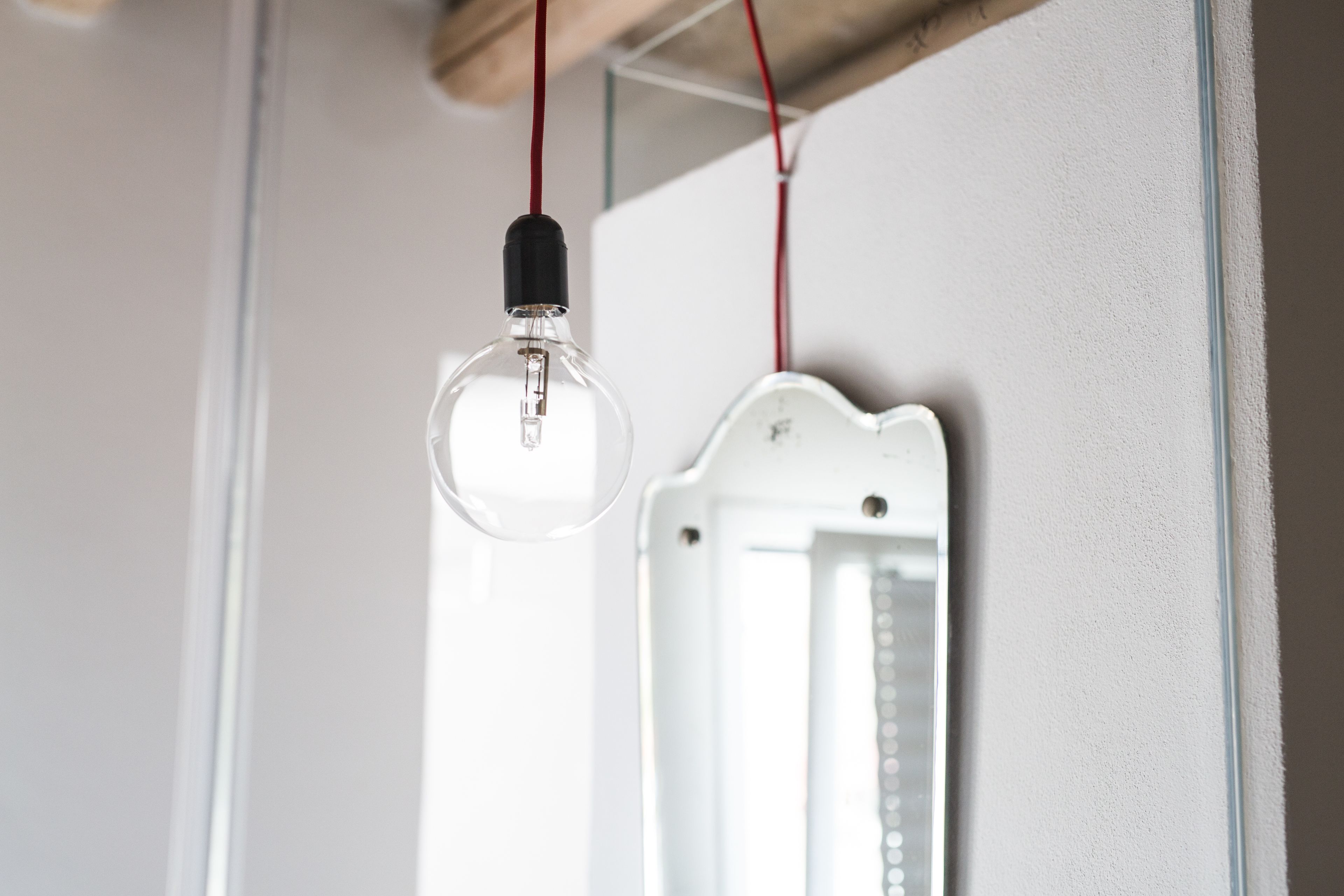 A light bulb hanging from a ceiling, connected to a white electrical box.