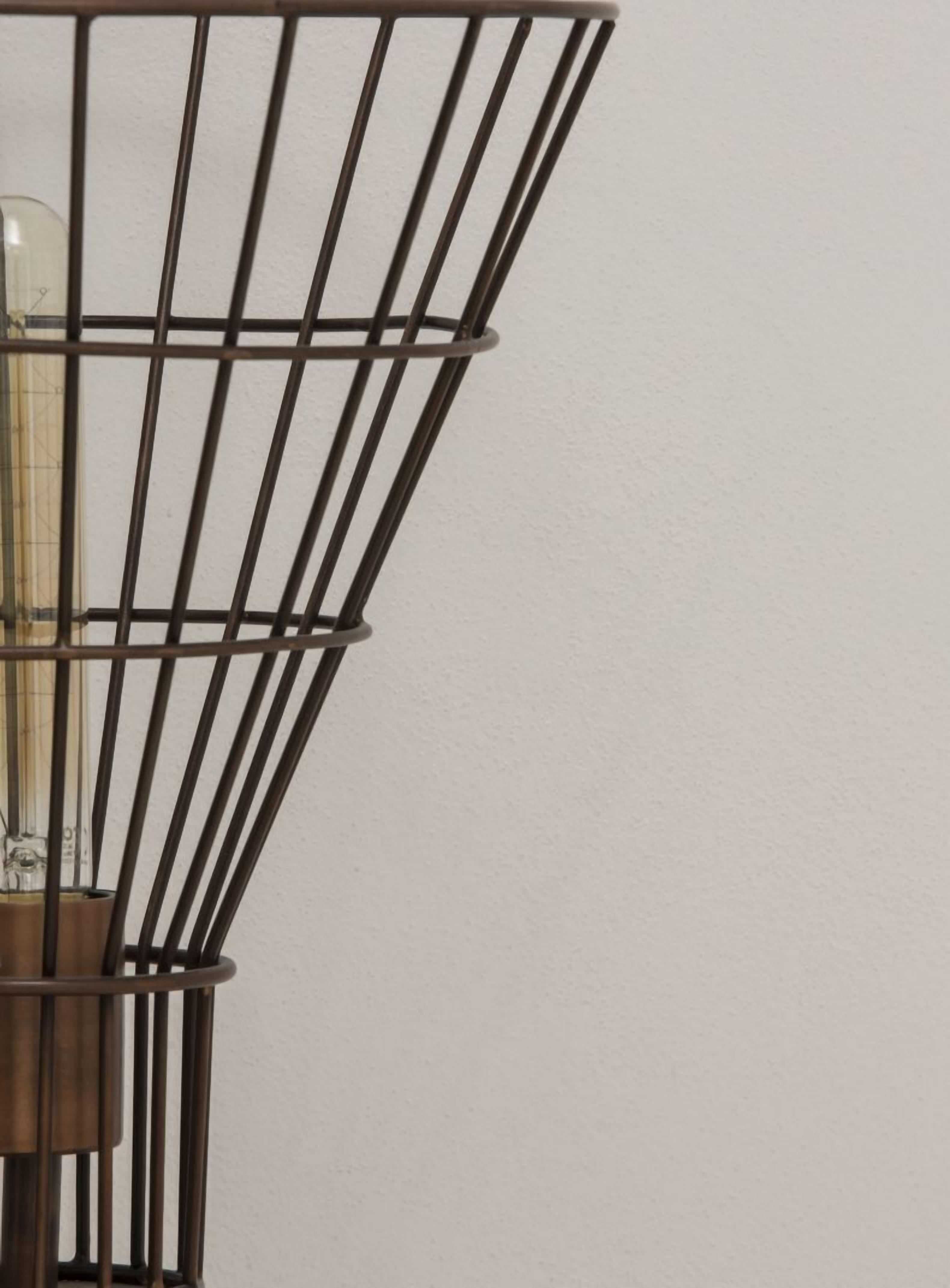 A metal-framed light fixture with a glass bulb, mounted on a wall.