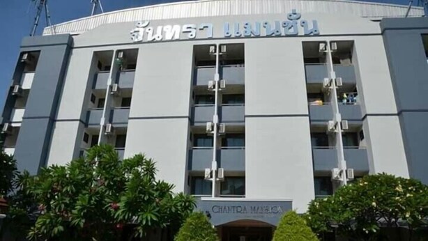 Un edificio de varios pisos con un cartel que dice "Chantra Manor".