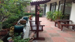 Un patio con fuente, bancos y plantas en macetas.