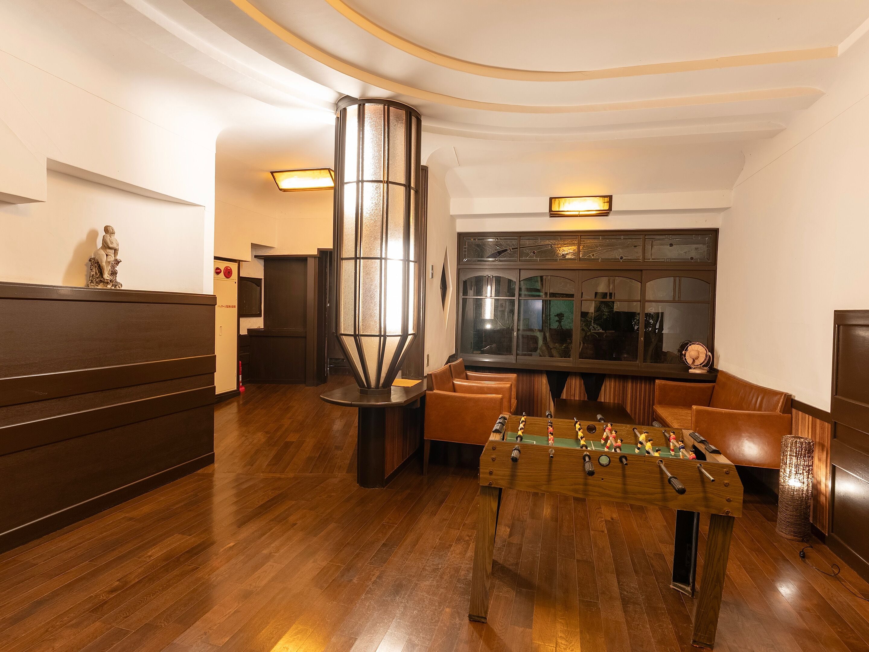 A lobby with a foosball table, seating area, and a large window with a view.