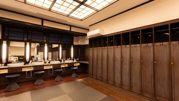 Une salle de bain moderne dotée d’un puits de lumière, de plusieurs lavabos et de casiers.