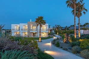 Vista frontal de la propiedad por la tarde o noche