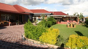 A building with a red roof and brick pathway leading to the entrance. - Honeybed Lodge (Lusaka)