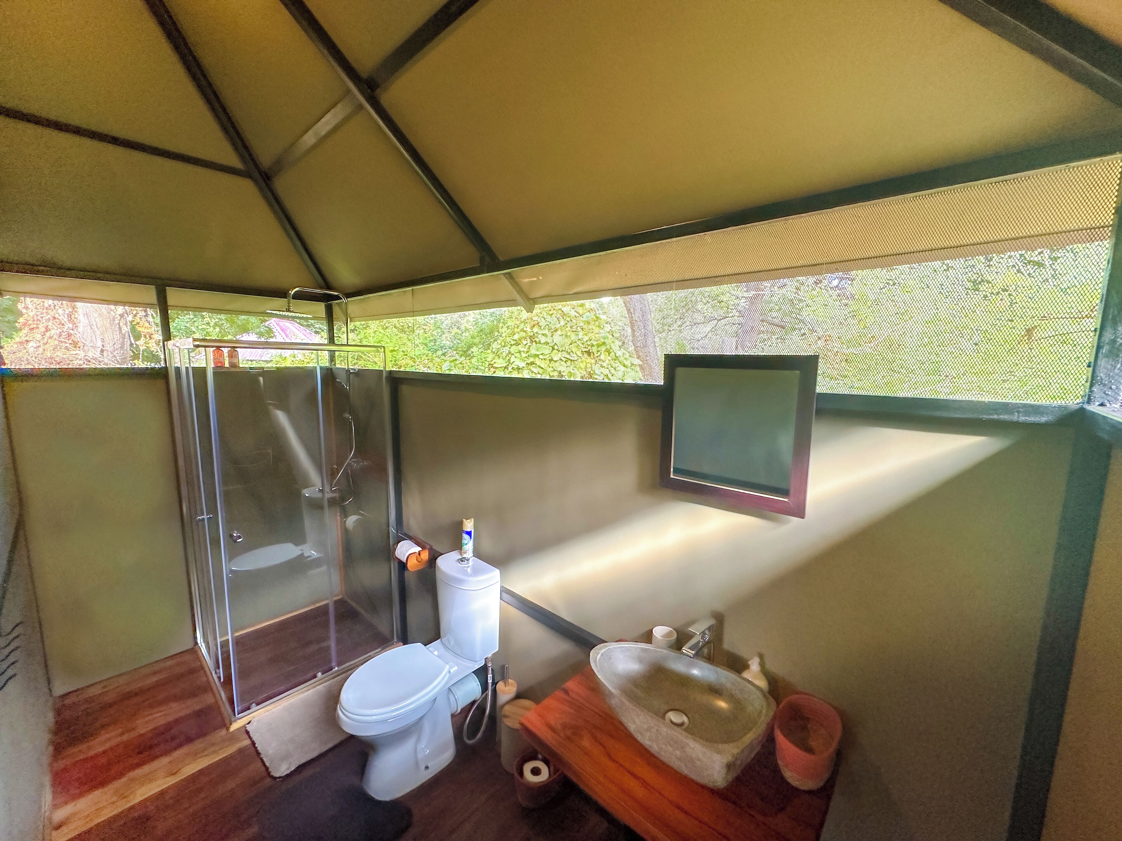 A compact bathroom with a toilet, sink, and shower.