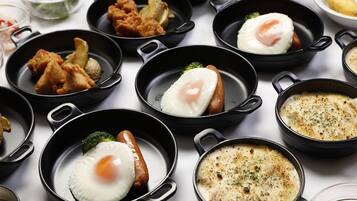 A variety of dishes in black pans on a table.
