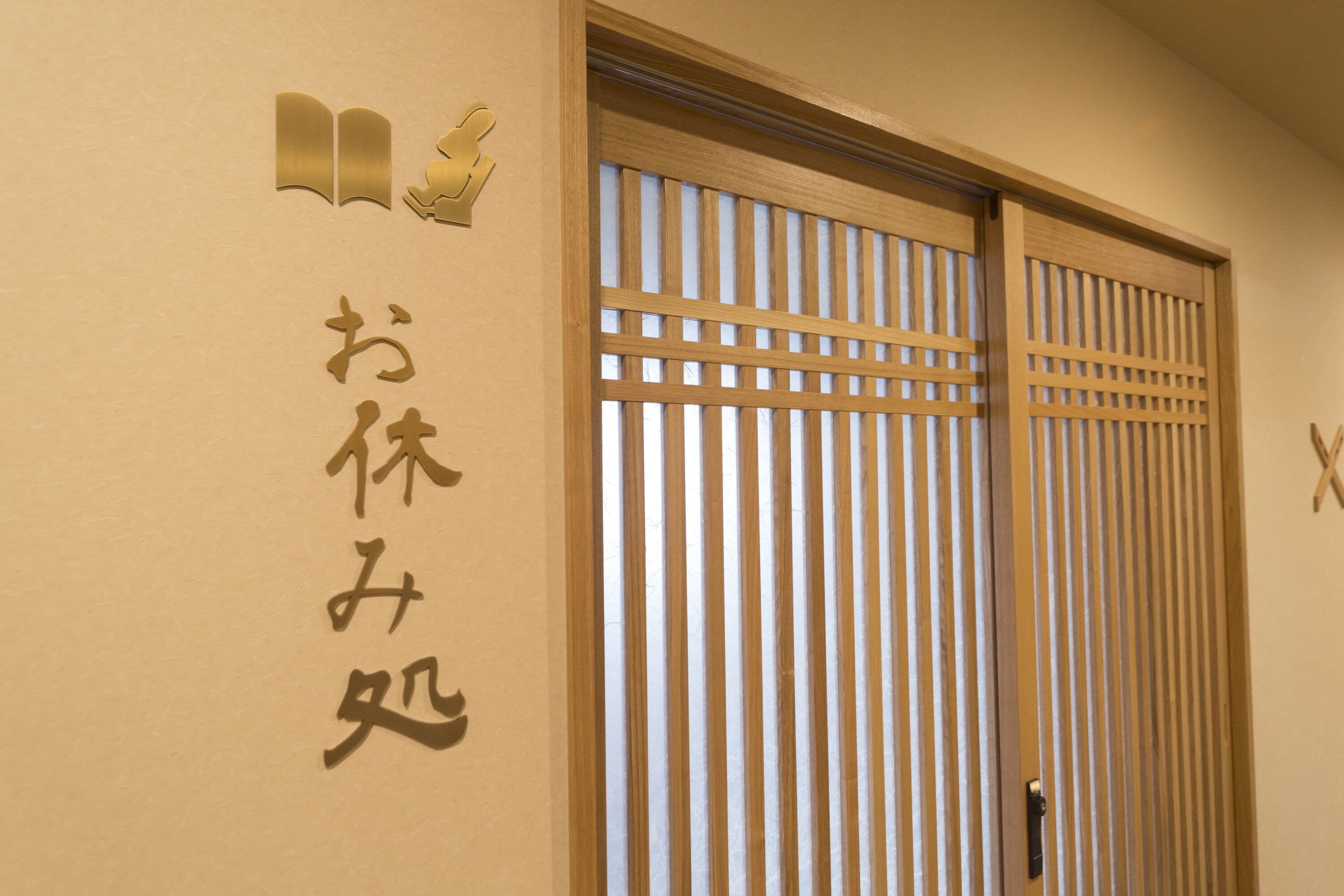 Una puerta corredera japonesa tradicional con listones verticales, un marco de madera y un pequeño tirador.
