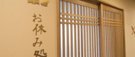 Una puerta corredera japonesa tradicional con listones verticales, un marco de madera y un pequeño tirador.