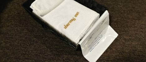 A neatly folded white towel with gold lettering in a black tray.