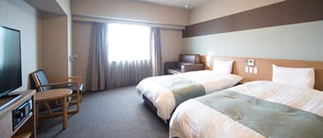 Une chambre d’hôtel avec deux lits, une télévision, un bureau et une chaise.