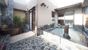 A spa area with a stone-tiled floor, a hot tub, and a small pool.