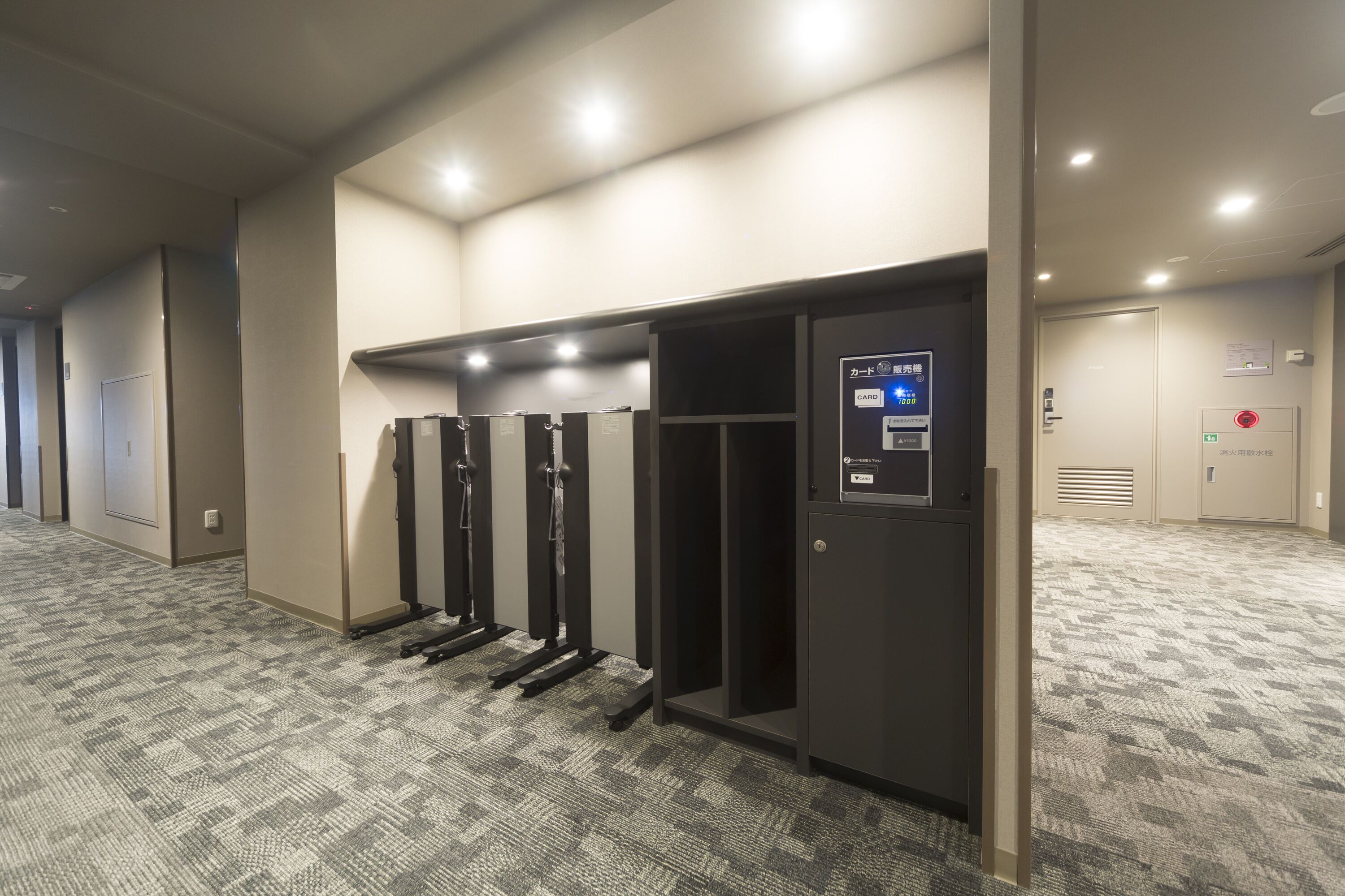 A hotel corridor with a self-service elevator, a card reader, and a fire alarm.